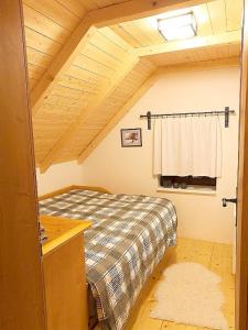 ein Schlafzimmer mit einem Bett und einer Holzdecke in der Unterkunft Nadgalerii Soláň in Velké Karlovice