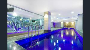a swimming pool in a building with a gym at CBD Deluxe Private 2 Bedroom Apartment in Adelaide