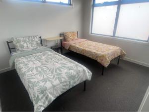 1 dormitorio con 2 camas y ventana en Brand new comfortable room in a beautiful suburb, en St Albans