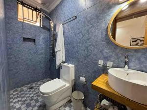 een badkamer met een wastafel, een toilet en een spiegel bij Nzuri Nest -Queen in Kigali