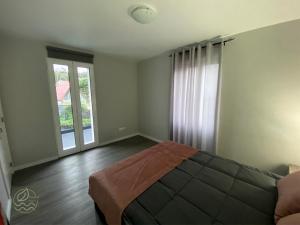 ein Schlafzimmer mit einem Bett und einem großen Fenster in der Unterkunft My Little Home Cottage 2 Bedrooms - Soulful Stays in Porto Moniz