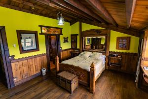 a bedroom with a bed and yellow walls and wooden floors at Prada a Tope - Palacio de Canedo in Canedo