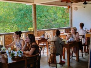 eine Gruppe von Personen, die in einem Restaurant an Tischen sitzen in der Unterkunft The Jungle View in Mirissa