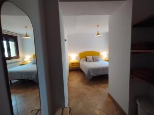 Habitación con vistas a un dormitorio con 2 camas y espejo. en Apartamento Rosellas, cerca de Alquézar, en Sierra de Guara en Adahuesca