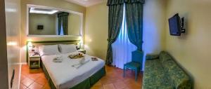 een slaapkamer met een bed, een stoel en een spiegel bij Best Western Hotel La Conchiglia in Palinuro