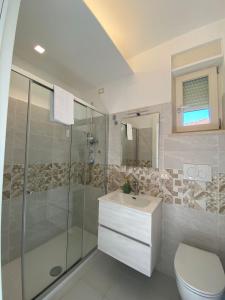 ein Bad mit einer Dusche, einem Waschbecken und einem WC in der Unterkunft MAF B&B in Cupello