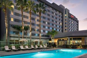 a hotel with a swimming pool and palm trees at Bakersfield Marriott at the Convention Center in Bakersfield