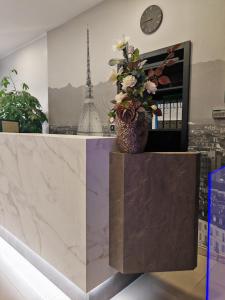 a vase with flowers on top of a marble counter at Hotel Romano in Turin