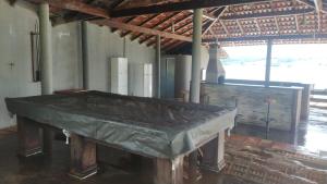 una gran mesa de madera en una habitación con chimenea en Rancho dos Deuses en Guapé