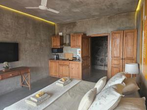 een woonkamer met een bank, een tafel en een televisie bij Les Terrasses Suites in Calheta