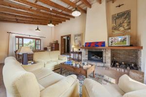 a living room with white furniture and a fireplace at Villa Es Barracar in Selva