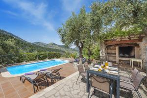 a patio with a table and chairs and a swimming pool at Villa Es Barracar in Selva