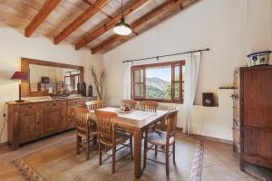 a dining room with a wooden table and chairs at Villa Es Barracar in Selva