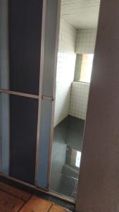 グアペにあるRancho dos Deusesのガラスのドアと鏡が備わるバスルーム