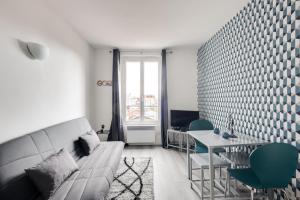 a living room with a couch and a table at 806 Suite Magic - Superb Apartment in Bagnolet