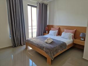 a bedroom with a bed with a stuffed animal on it at Apartamentos Beira-Mar in Mindelo