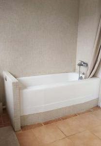 bañera blanca en una habitación en Maison dans parc privé (JO 2024), en La Celle-Saint-Cloud