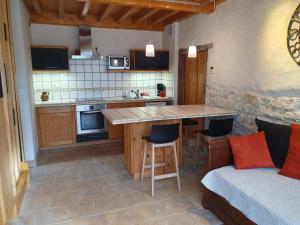 - une cuisine avec une table et un canapé dans une chambre dans l'établissement Chambres d'Hôtes Grange Carrée, à Saint-Rémy