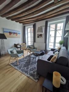 uma sala de estar com um sofá, cadeiras e uma mesa em Saint-Ger, what else ! em Saint-Germain-en-Laye