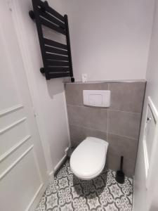 uma pequena casa de banho com um WC branco e piso em azulejo em Saint-Ger, what else ! em Saint-Germain-en-Laye