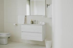 a white bathroom with a toilet and a sink at MAF B&B in Cupello