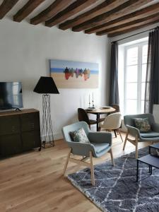 uma sala de estar com uma mesa e cadeiras e uma mesa em Saint-Ger, what else ! em Saint-Germain-en-Laye