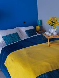 a blue room with a bed with a yellow blanket at Casa di Giove room in Pompei
