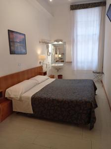 1 dormitorio con cama, espejo y ventana en Hotel Caneva en Venecia