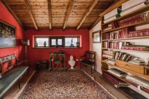 a living room with red walls and a book shelf at Torre del 1300 Un atto damore in Castiglione