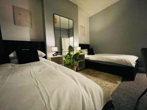 1 dormitorio con 2 camas y espejo en Cosy 3 Bed Home City Centre, en Parkside