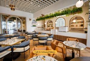 een restaurant met tafels en stoelen en een bar bij The First Collection Waterfront in Dubai