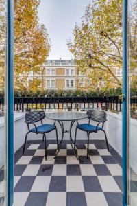 a patio with a table and chairs on a checkered floor at Mornington Hotel London Kensington, BW Premier Collection in London