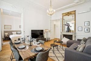 a living room with a table and chairs and a couch at 307-Suite Serbie - Superb apartment in Paris in Paris