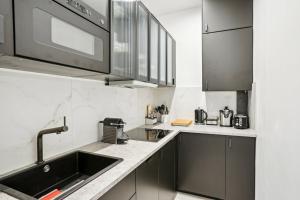 eine Küche mit einer Spüle und einer Mikrowelle in der Unterkunft 307-Suite Serbie - Superb apartment in Paris in Paris