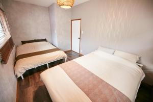 a bedroom with two beds in a room at Hakone Yumoto Base in Hakone