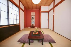 a living room with red walls and a table at Hakone Yumoto Base in Hakone