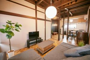 a living room with a couch and a television and a table at Hakone Yumoto Base in Hakone