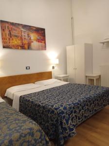 - une chambre avec 2 lits et un tableau mural dans l'établissement Hotel Caneva, à Venise