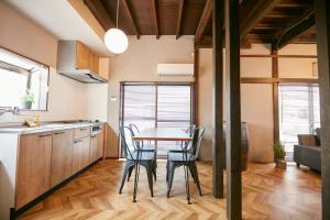 - une cuisine et une salle à manger avec une table et des chaises dans l'établissement Hakone Yumoto Base, à Hakone