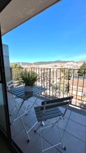 a balcony with a table and chairs and a view of the ocean at Dúplex con terraza by Prestigi in Terrassa