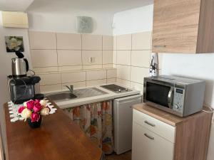 a kitchen with a table with a microwave and a sink at Apartment don bosco in Graz