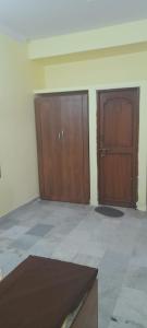 a room with two wooden doors and a tile floor at Al Amoodi Furnished Apartments in Hyderabad