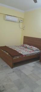 a wooden bed in a room with at Al Amoodi Furnished Apartments in Hyderabad