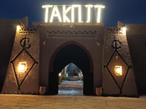 uma entrada para um edifício com uma placa que diz tiki em Takojt em Merzouga