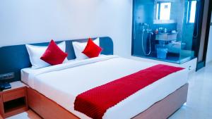 a bedroom with a large bed with red pillows at Hsquare Hotel Andheri West in Mumbai