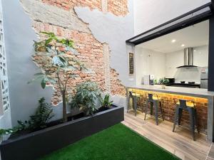 uma cozinha com uma parede de tijolos e um bar com bancos em Galaria 4BR 17Pax NearTC, DinosaurLand, PS4, Netflix em Kuantan