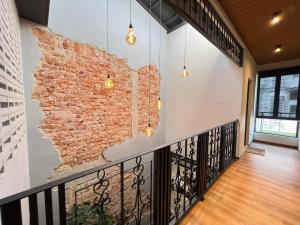 a brick wall in a hallway with pendant lights at Galaria 4BR 17Pax NearTC, DinosaurLand, PS4, Netflix in Kuantan