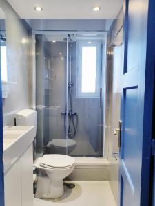 a bathroom with a toilet and a glass shower at KYMA Apartments - Athens Acropolis 1 in Athens