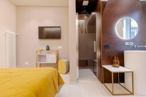1 dormitorio con cama amarilla y espejo en FLORENCE SEASONS B&B, en Florencia