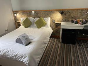 The Six Bells Hotel في انفيلد: سرير أبيض كبير في غرفة مع مكتب